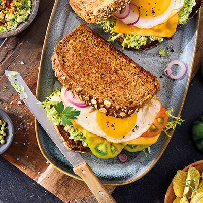 Sándwich de pan rústico con brócoli, huevo frito y queso 