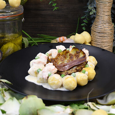 Gnocchi de queso burrata y albahaca con alcachofas y gambones 