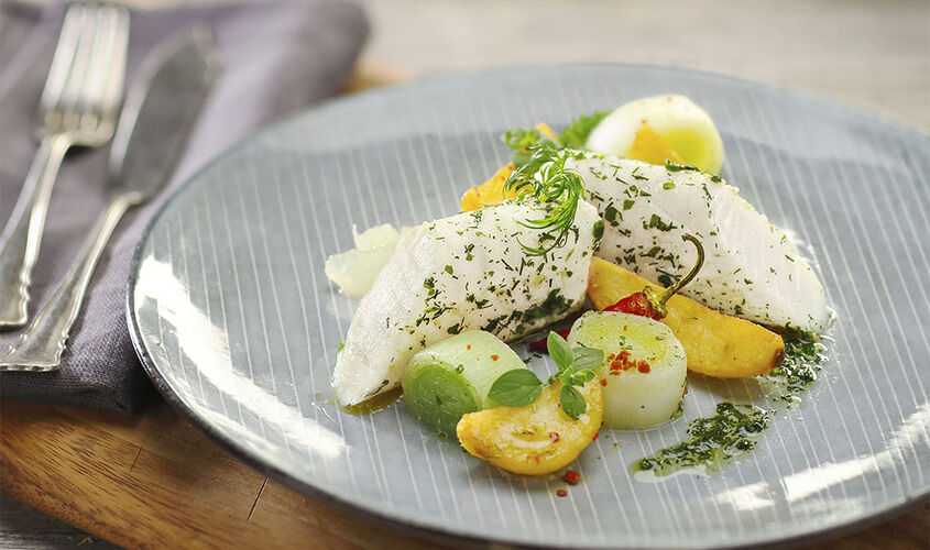 Lomo de merluza del cabo marinado en aceite de hierbas y lim&oacute;n al vapor sobre puerro
