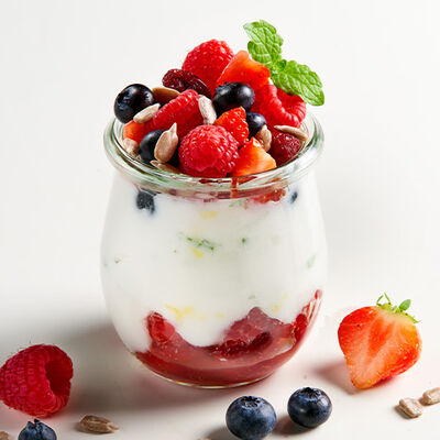 Vaso de yogur cremoso con frutos del bosque