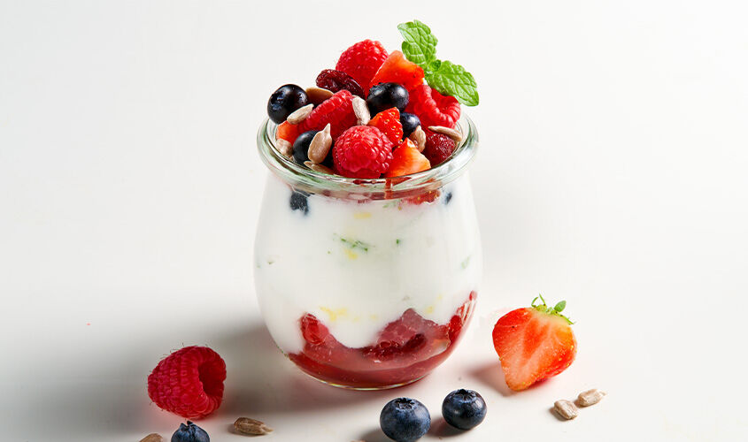 Vaso de yogur cremoso con frutos del bosque