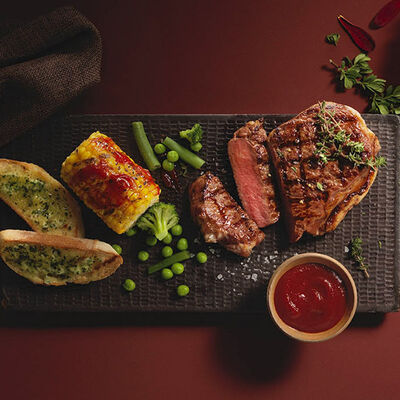 Bistec al grill con mazorcas de maíz a la barbacoa
