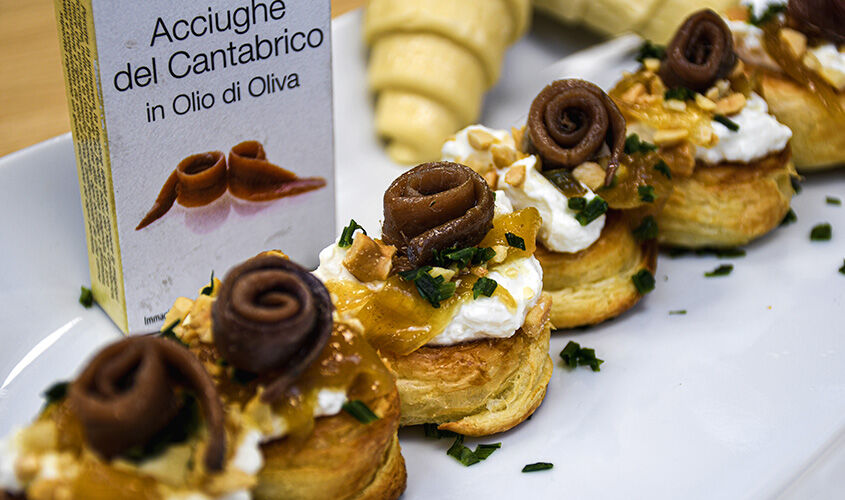 Croissant con nuestras anchoas, crema agria de padano y cebolla caramelizada 