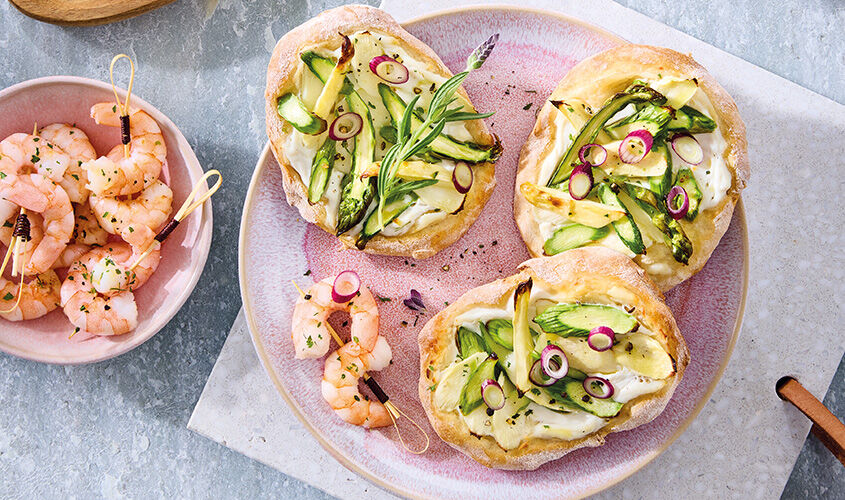 Pizzettis de esp&aacute;rragos y crema ib&eacute;rica de queso con colas de gamb&oacute;n 